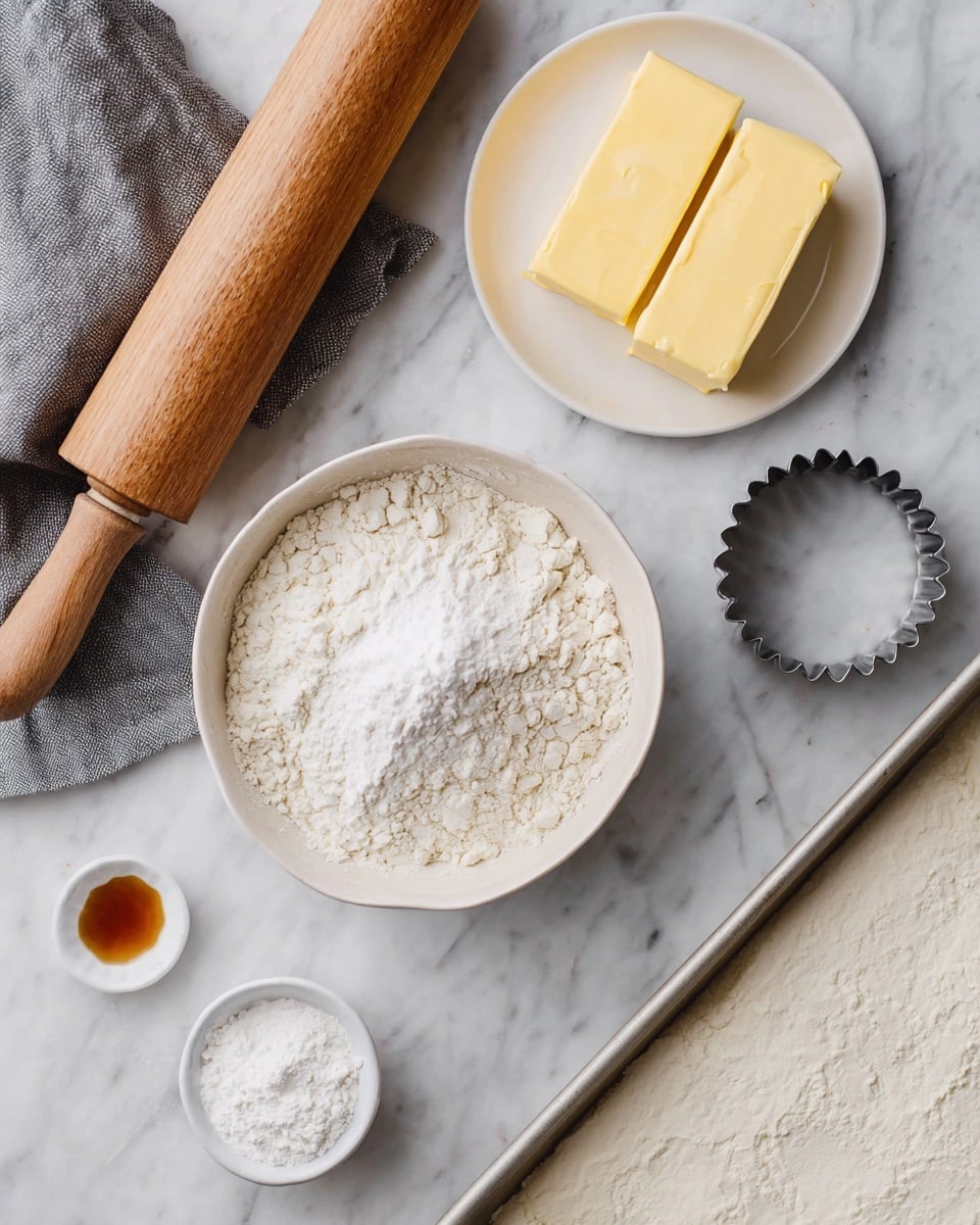 The image shows an overhead view of baking ingredients and tools arranged neatly on a white marbled surface. There are two rectangular yellow blocks of butter placed side by side on a small white plate at the top right. Below that is a white bowl filled with fine powdered sugar that looks fluffy. Next to it on the left is a large white bowl filled with all-purpose flour, with a small depression in the center. A small white dish holds a small amount of vanilla extract near the bottom left. To the top left, there is a wooden rolling pin resting on a gray cloth. Near the center right is a round metal cookie cutter with scalloped edges. At the bottom right, part of a white baking tray lined with parchment paper is visible. The overall scene is clean and simple, showing the ingredients ready to be used. photo taken with an iphone --ar 4:5 --v 7