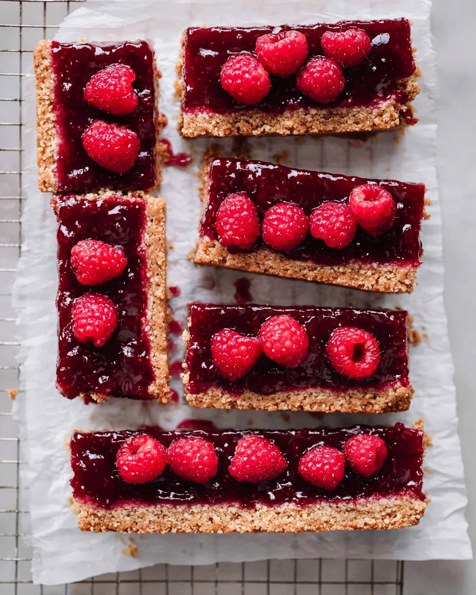 The image shows six rectangular dessert bars placed on white parchment paper over a white marbled surface with a cooling rack. Each bar has two distinct layers: a thick, light brown crumbly base with a coarse texture, and a glossy dark red fruit topping with a shiny, slightly uneven surface made from raspberry jam. Bright red raspberries are placed unevenly on the top layer of each bar, adding a fresh and vibrant contrast to the deep red jam. Some jam has slightly spread onto the parchment, enhancing the homemade look. The bars are arranged in a neat grid, showing both the surface and the sides of the layers clearly, photo taken with an iphone --ar 4:5 --v 7