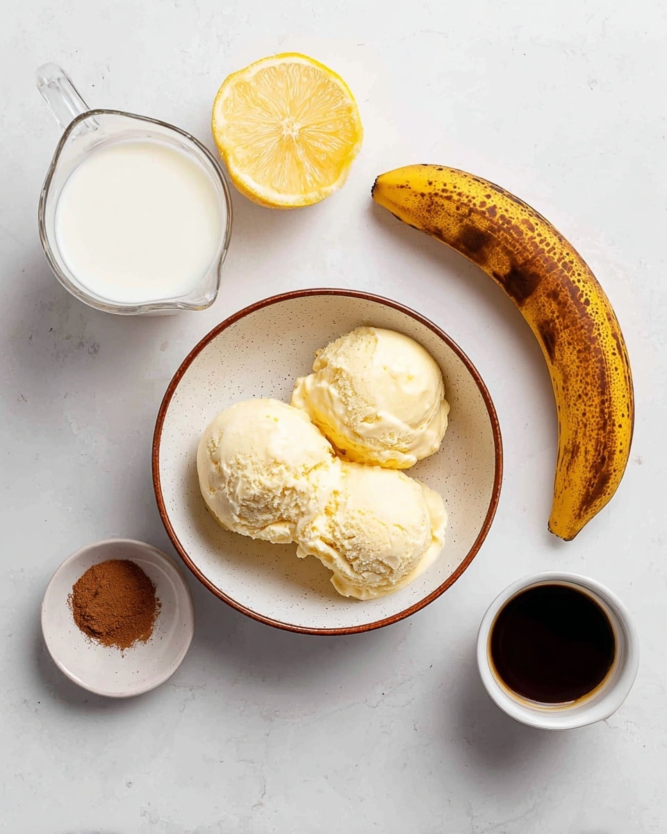 The image shows three scoops of light yellow ice cream, slightly melting, inside a white bowl with a speckled texture and a thin brown rim. To the top left of the bowl, there is a clear glass measuring cup filled with white milk. Just above the bowl is a half lemon showing its bright yellow, juicy inside. A whole ripe banana, with brown spots on its yellow skin, lies to the right of the lemon and bowl. Below the banana, there is a small white bowl containing a small amount of brown cinnamon powder. Next to the cinnamon bowl, closer to the bottom right, is a white ramekin filled with dark brown liquid, likely espresso. All these items are placed on a white marbled surface. Photo taken with an iphone --ar 4:5 --v 7