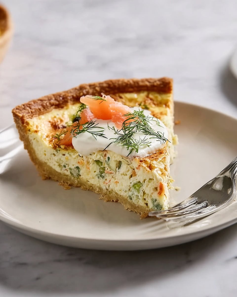 A round pie with a golden-brown, wavy crust sits on a white plate, the crust puffed and flaky with a smooth, pale yellow filling sprinkled evenly with small bits of green herbs and dill. The pie surface looks soft with scattered fresh herb pieces adding texture and color contrast. A small white bowl beside the plate holds fresh green dill sprigs, and a knife with a silver blade and wooden handle lays flat next to the plate on a white marbled surface. The overall look is fresh and light, with natural colors and soft, smooth textures. photo taken with an iphone --ar 4:5 --v 7