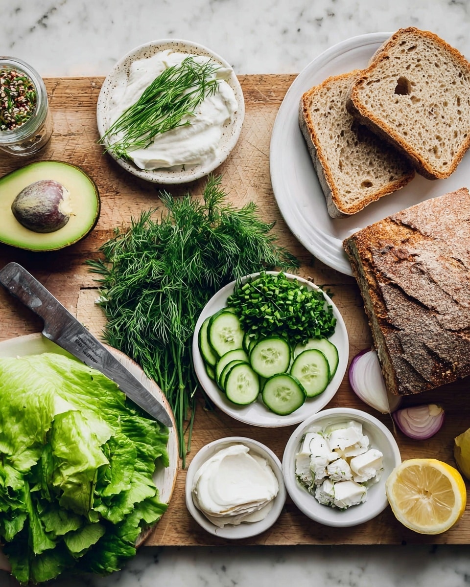 The image shows fresh ingredients for a sandwich laid out on a white marbled surface. There are two slices of light brown sourdough bread on a white plate at the top right, next to a larger piece of crusty brown bread with a rough texture on a wooden board beside a serrated knife with a dark handle. To the bottom left of the board is a halved avocado with a dark brown seed and bright green flesh. Around it are fresh green herbs like dill, chives, and parsley piled neatly on a white plate. There is a small heap of green leafy lettuce at the bottom. Small white bowls hold thin cucumber slices, white creamy spread, white soft cheese, and green sprouts. A halved lemon and small red onion pieces are on a white dish near the bottom center. Photo taken with an iphone --ar 4:5 --v 7
