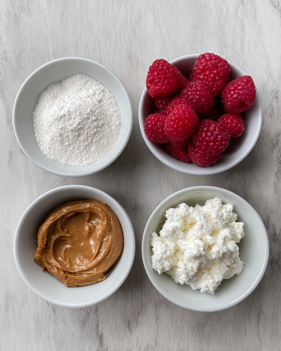 The image shows four small white bowls placed on a white marbled surface. The top left bowl holds a white powder with a soft, powdery texture. The top right bowl contains a small pile of fresh, bright red raspberries with a bumpy texture. On the bottom left, the bowl has a smooth, thick layer of brown peanut butter, slightly shiny and creamy. The bottom right bowl is filled with white cottage cheese, showing a lumpy and soft texture. The bowls are spaced evenly in a square shape. Photo taken with an iphone --ar 4:5 --v 7