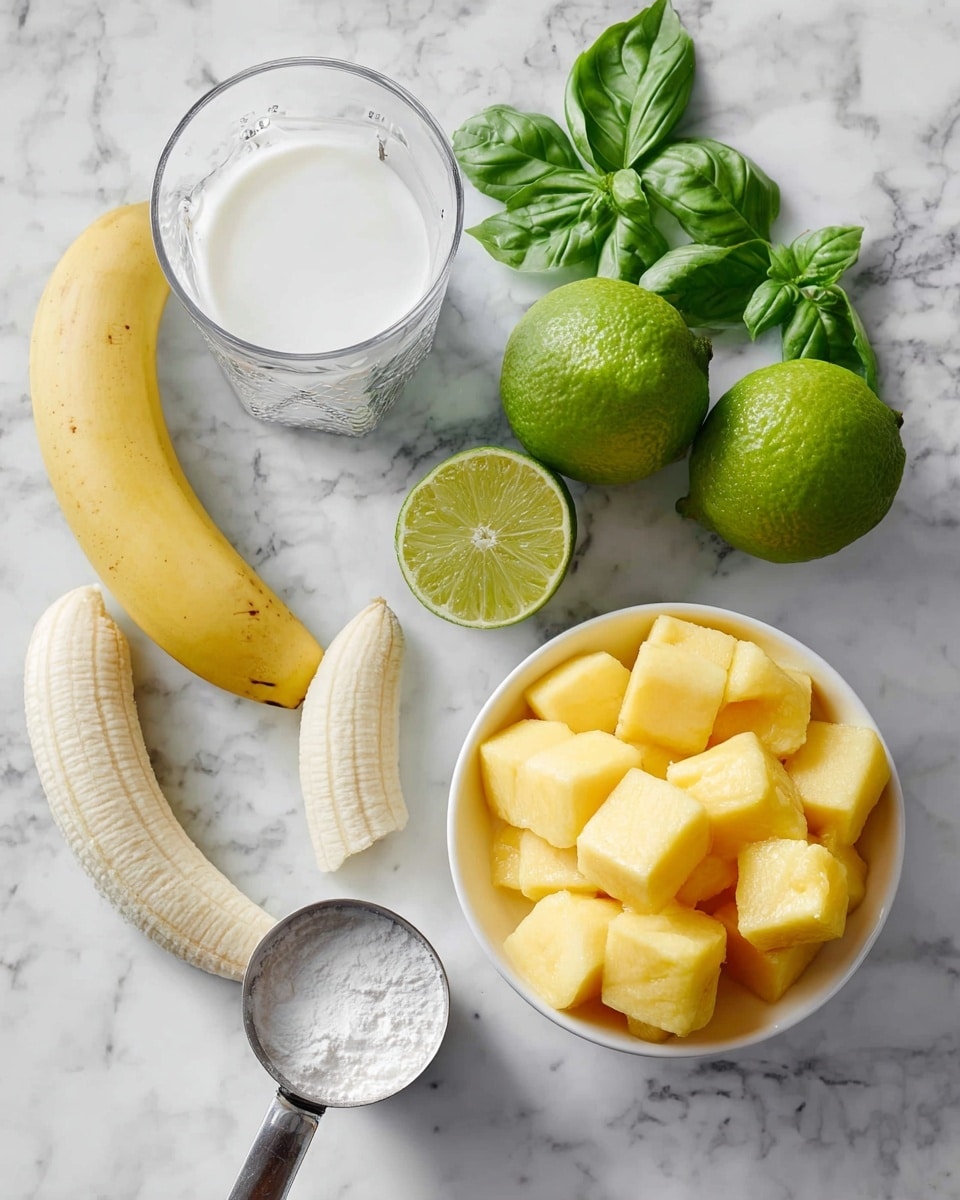 The image shows ingredients arranged on a white marbled surface. There is a bowl filled with yellow frozen mango chunks in the bottom right part of the image. Near the bowl, a peeled banana lies horizontally, with a second unpeeled banana curving along the bottom left edge. Above the bananas, a glass filled with white liquid is visible. To the right of the glass, two bright green limes, one whole and one cut in half showing its light green inside, sit next to a silver lime juicer. Fresh green basil leaves are scattered near the top left, adding a vibrant touch. A metal measuring cup filled with a white powder, likely yogurt or cream, is placed near the bottom center. Photo taken with an iphone --ar 4:5 --v 7