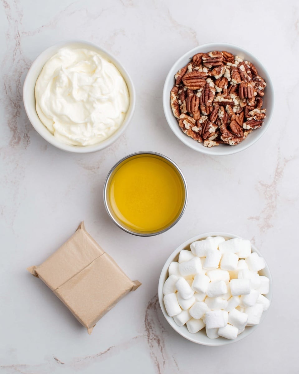 The image shows five different food items placed on a white marbled surface. At the top left, there is a white bowl filled with smooth, white cream. To the right of this bowl, there is another white bowl containing broken pecan nuts with brown and tan rough textures. Below these two bowls, in the center, sits a small silver container filled with a bright yellow, slightly textured liquid. In the bottom right corner, there is a white bowl filled to the top with small, white marshmallows that have a soft and fluffy look. In the bottom left corner, there is a small, square, light brown wrapped package with folded edges. photo taken with an iphone --ar 4:5 --v 7