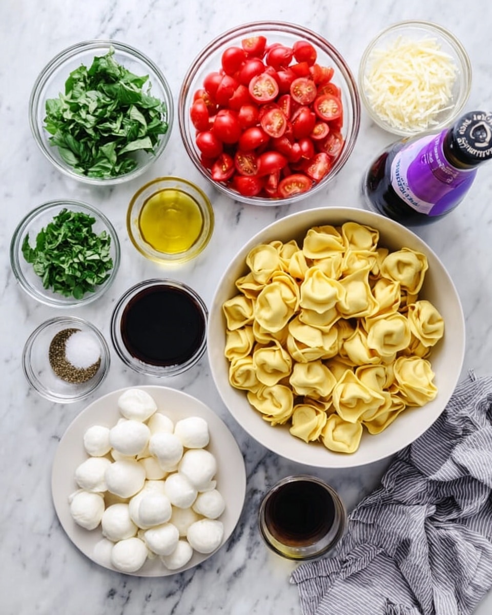 The image shows a white marbled surface with several glass and white bowls arranged neatly. In the center, there is a white bowl filled with yellow tortellini pasta. Around it, there are small glass bowls containing chopped green basil leaves, halved red cherry tomatoes, and shredded white cheese. One white plate holds small white mozzarella balls. Various small glass bowls hold olive oil, black pepper, salt, and a dark red balsamic vinegar. There is also a purple-bottled liquid lying on the surface, along with a gray and white striped cloth on the right side. photo taken with an iphone --ar 4:5 --v 7