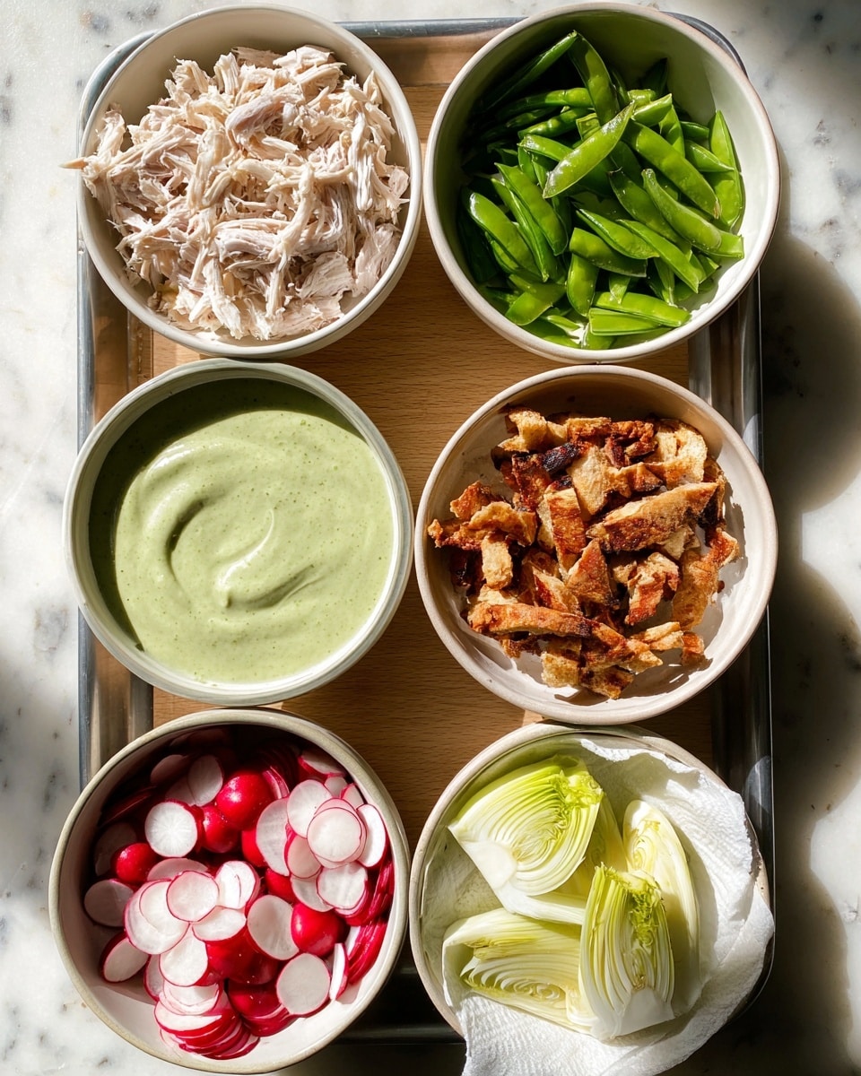 The image shows six bowls on a white marbled surface, each holding different food ingredients arranged neatly on a metal tray. Starting from the top left, there is a white bowl filled with shredded white meat placed in a white bowl, to its right is a white bowl with fresh, sliced green snap peas. Below the shredded meat is a white bowl with a smooth, creamy pale green sauce. To the right of the sauce is a white bowl filled with crispy browned bread pieces on a white paper towel. Below the sauce bowl is a white bowl with thinly sliced round radishes showing white centers and red edges, and to the right of the radishes is a white bowl filled with pale sliced fennel with light green stalks visible. The light shines from above casting slight shadows, making the colors and textures clear. Photo taken with an iphone --ar 4:5 --v 7