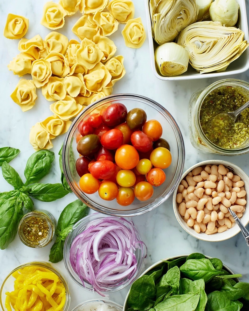 A spread of fresh ingredients is arranged on a white marbled surface. On the left, there are bright green basil leaves next to a pile of three different shapes of uncooked yellow tortellini pasta scattered across the surface. In the center, a clear glass bowl fills with light beige cannellini beans, surrounded by cherry tomatoes in shades of red, orange, and yellow placed inside a small white container. Above the beans, a white bowl holds pale yellow artichoke halves. To the right of the artichokes, a clear mason jar contains greenish herb dressing with a spoon resting inside. At the bottom, a white bowl with thin slices of purple onion sits near a bowl of fresh dark green spinach leaves. There is also a small glass bowl of yellow pickled peppers. photo taken with an iphone --ar 4:5 --v 7