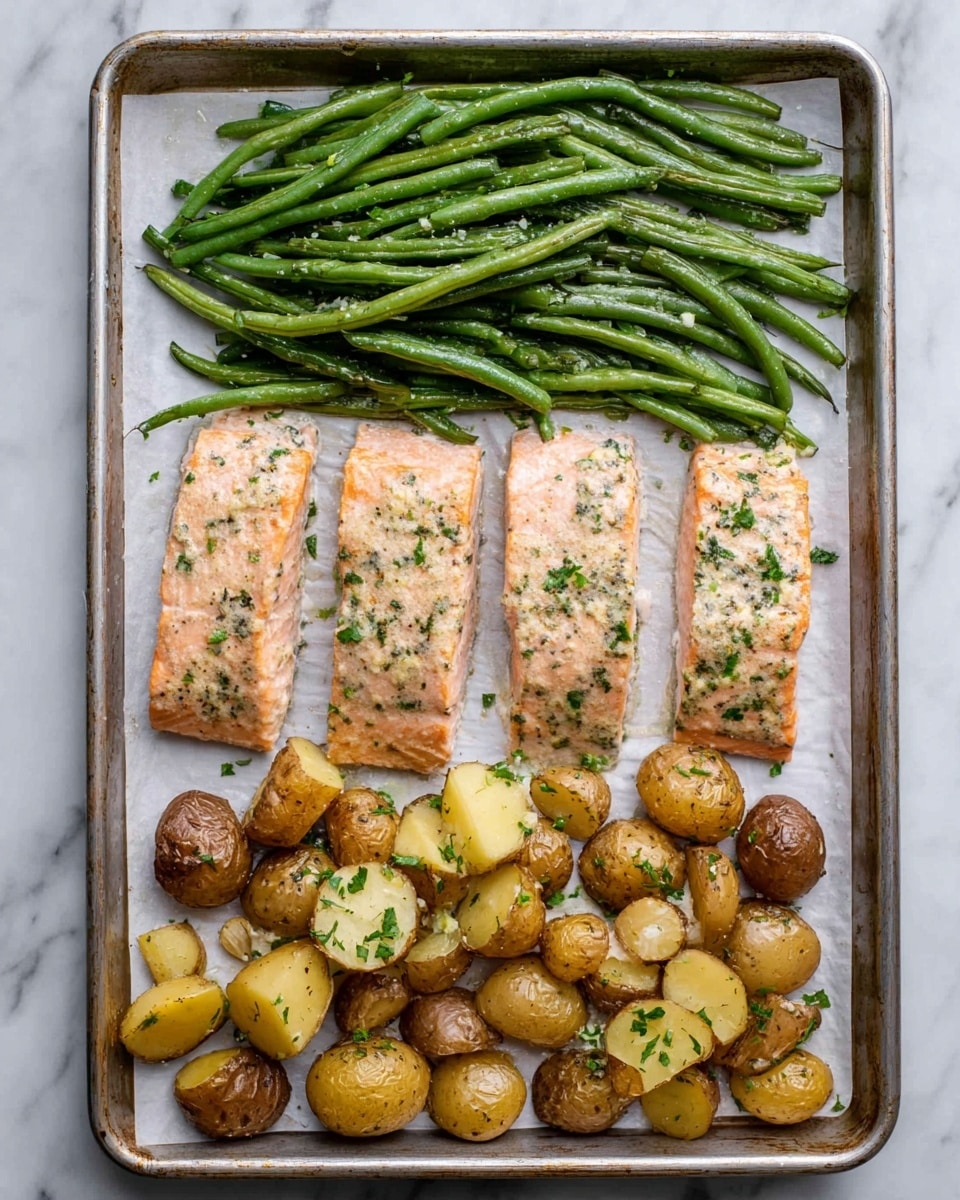 The image shows a metal baking tray with three layers of food neatly placed on white parchment paper. At the top layer, there is a row of cooked green beans that are shiny and sprinkled with small bits of seasoning. In the middle layer, four pieces of roasted salmon fillets are lined up, each with a pale pink color and a light coating of herbs, giving a slightly speckled green look. The bottom layer has a mix of whole and halved small potatoes that are golden brown with a sprinkle of herbs and bits of garlic, creating a textured look. The tray rests on a white marbled surface. Photo taken with an iphone --ar 4:5 --v 7