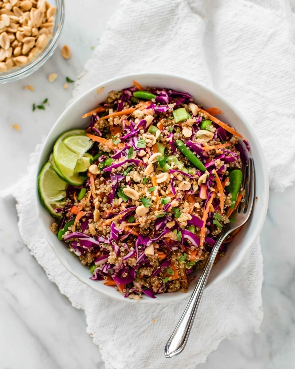 A colorful quinoa salad sits in a large white bowl on a white marbled surface, showing about three main layers: the base layer of small, round, beige quinoa grains, mixed with thin, bright orange shredded carrots, green snap pea pieces, and thin purple cabbage strips layered evenly throughout. There are small bits of fresh green herbs scattered all over, adding a fresh texture. The salad looks light and fresh with a few shiny specks of dressing. A silver utensil with a black handle is partly visible on the right side of the bowl, and a black fork rests inside the mix on the left side. photo taken with an iphone --ar 4:5 --v 7