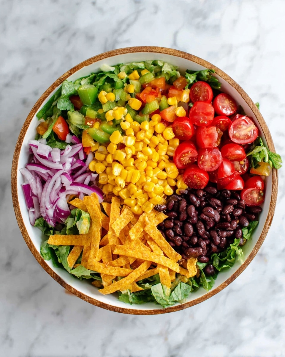A white bowl with a wooden rim holds a colorful salad arranged in separate sections on a bed of green lettuce; bright yellow corn kernels sit at the top center, to the right of that are halved red cherry tomatoes, below the tomatoes are crispy golden tortilla strips, under those lie dark black beans, to the left of the beans is diced yellow and green bell pepper, and above the peppers are thin slices of purple-red onion; the bowl is placed on a white marbled surface photo taken with an iphone --ar 4:5 --v 7