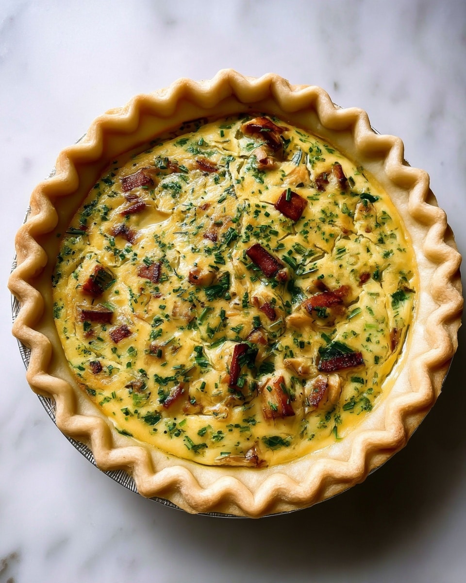 A round pie with a thick, light golden crust that has a wavy edge and holds the filling inside. The filling is creamy and yellow with bits of green herbs and small pieces of light brown cooked food spread evenly throughout. The pie sits on a white marbled surface. photo taken with an iphone --ar 4:5 --v 7